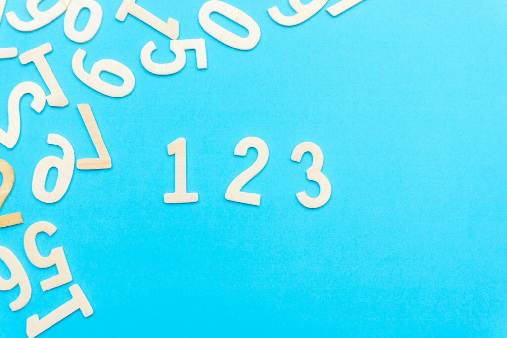 Creative layout of white numbers on a bright blue background, focusing on '123'.